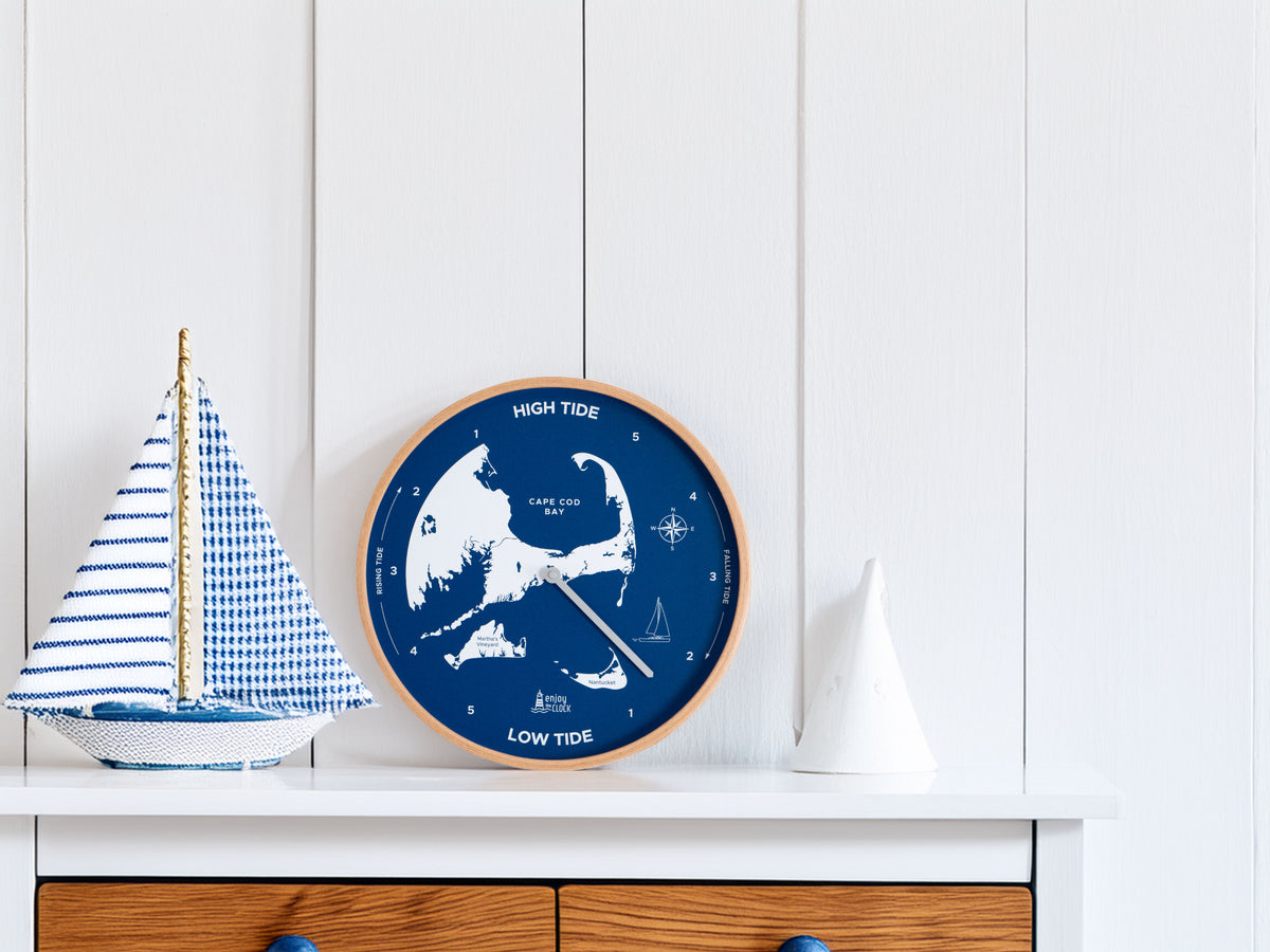 Cape Cod Tide Clock in Ocean Blue and Natural Wood on a modern dresser, showing tide levels. Perfect nautical decor for a stylish coastal touch.